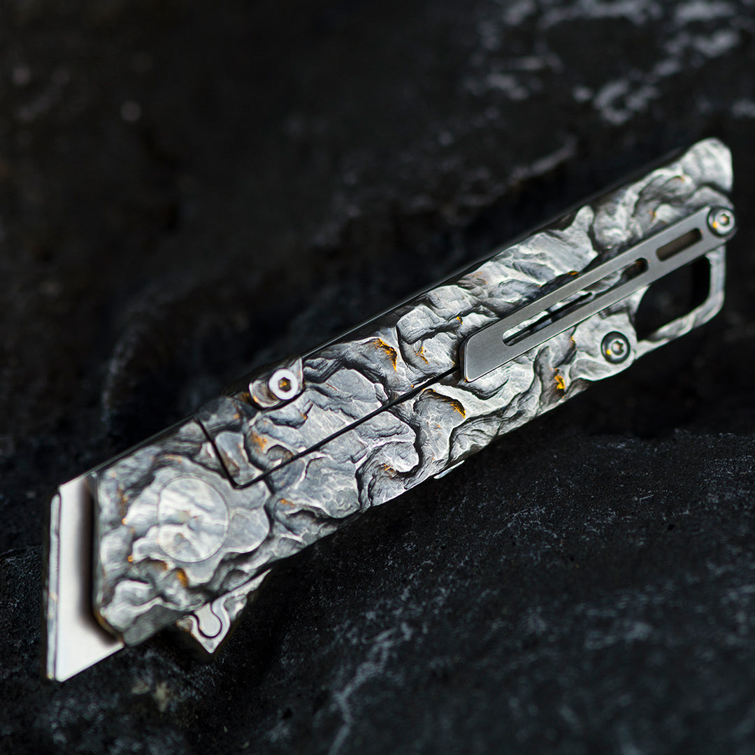 Cuchillo plegable utilitario de titanio con cuervo tallado a mano